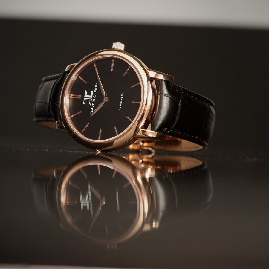 Watch resting on a mirror surface with its reflection